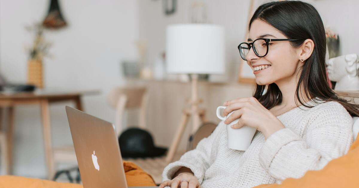 jeune femme prenant son café devant son ordinateur